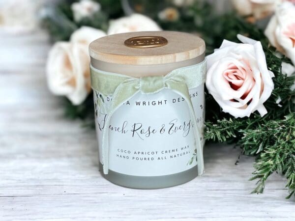 Scented candles with wooden wicks by Donna Wright Designs in French Rose & Evergreen 8 oz sitting on an antique wooden table. The best romantic fragrance combination!