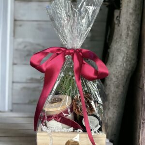 A Noble Fir & Juniper - 4 Oz gift basket with a red ribbon.