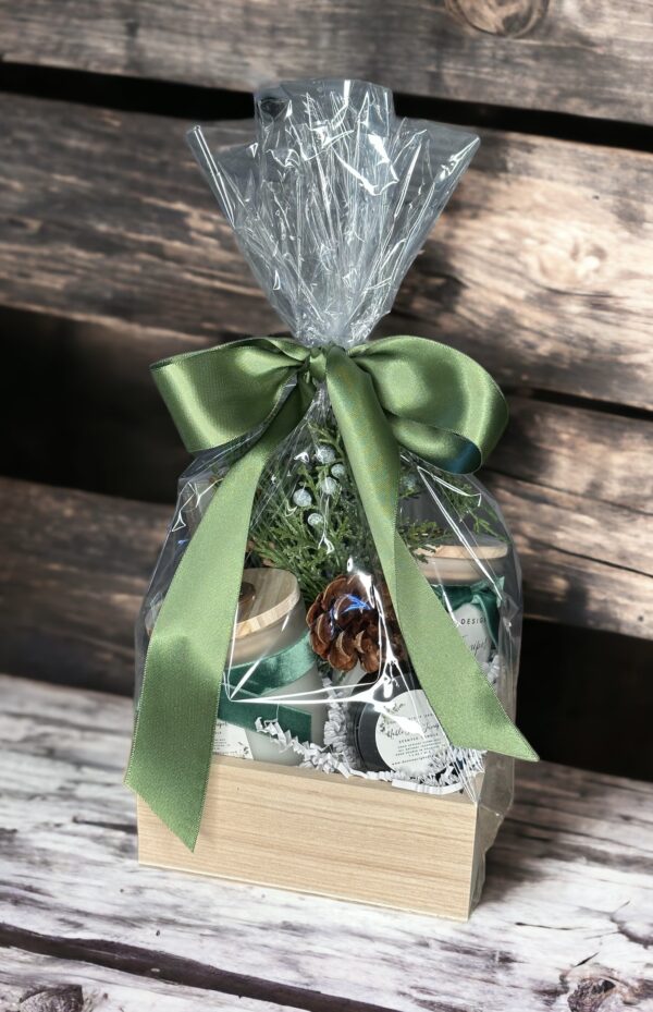 A Noble Fir & Juniper - 4 Oz gift basket with a green bow and pine cones.