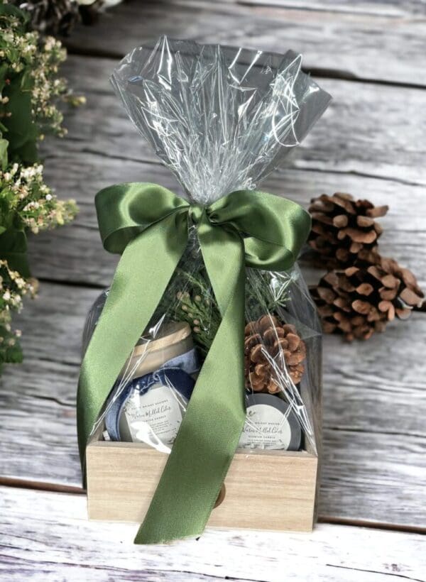 Warm Mulled Cider gift basket by Donna Wright Designs in a wood box wrapped in cellophane with a green satin ribbon makes the best luxury candle gift basket for anyone.
