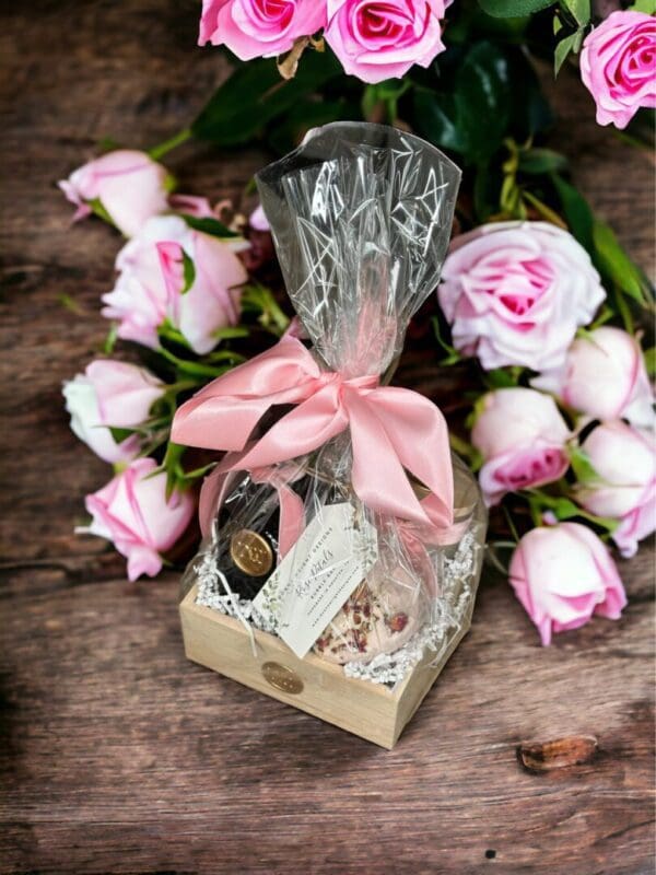 Spring Bouquet Gift Basket by Donna Wright Designs with perfume grade candles with wooden wicks, Spring Bouquet hand soap with all natural ingredients on a wood table with pink roses in the background