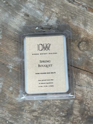 Donna Wright Designs A package of Donna Wright Designs' hand-poured wax melts labeled "Spring Bouquet" is displayed on a wooden surface. The package contains six 2.5 oz melts, made from all-natural ingredients with a base of coco apricot crème wax.