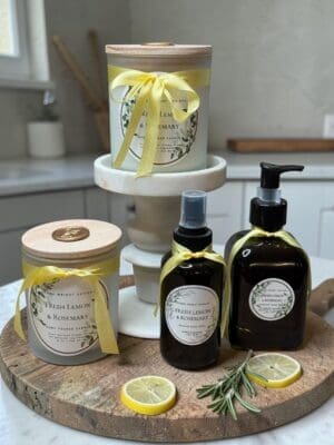 Luxury lemon and rosemary candle on marble surface with fresh lemons and rosemary sprig