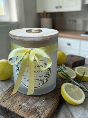 Luxury citrus herbal candle styled in a bright kitchen with lemons, rosemary and linen.