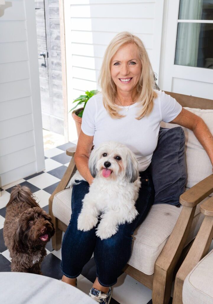 A woman sitting on a chair with two dogs.